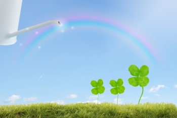 ジョウロで虹の水をかけてもらう四つ葉のクローバー