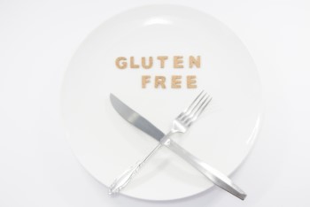 グルテンフリーの文字が置かれた白いお皿とフォークとナイフ