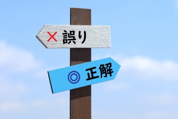 青空に「誤り」と「正解」の二つの看板