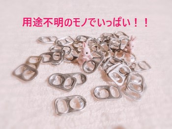 たくさんの空き缶のプルタブに埋もれるうさぎのミニチュア