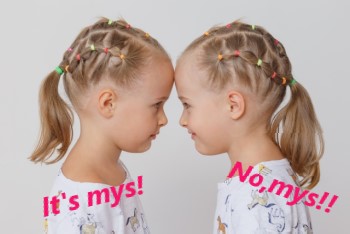 おでこをつけて見つめ合う双子の女の子