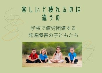 原っぱで座って笑う４人の子どもたち