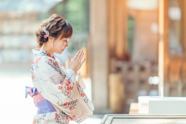 神社でお参りする女性