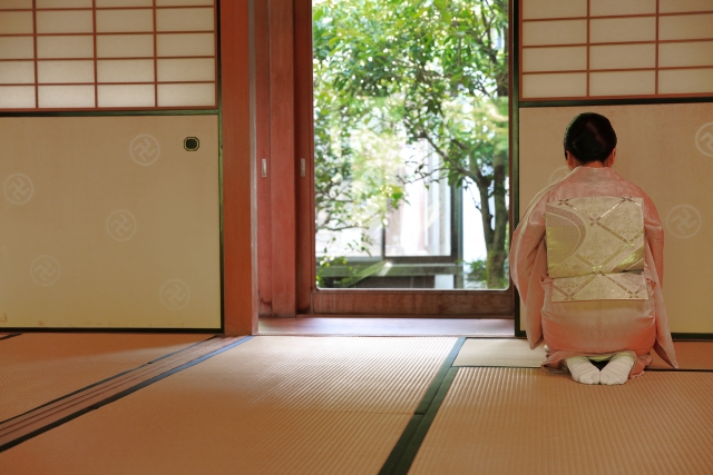 障子の傍に座る着物の女性