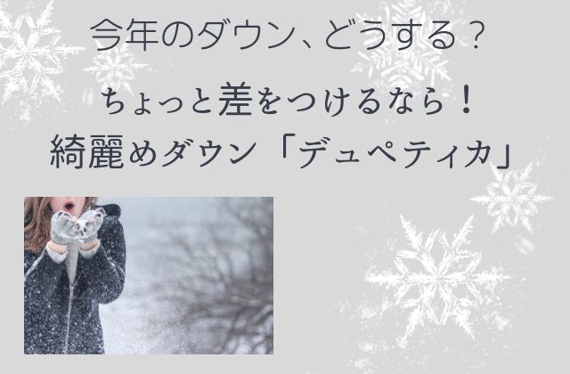グレーの背景にダウンを着た女性