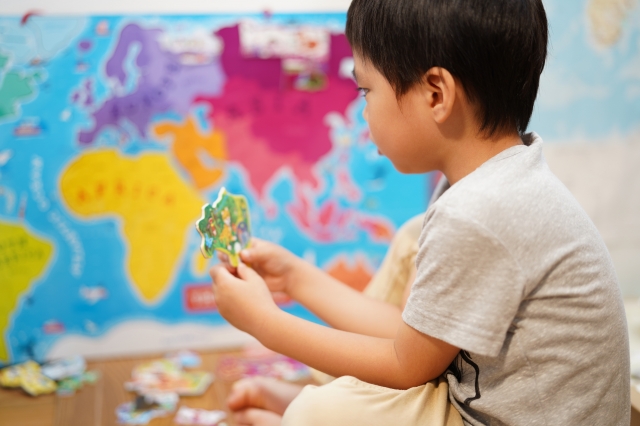 世界地図のパズルをするこども
