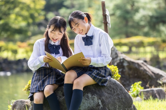 仲良くノートを見る女子中学生たち