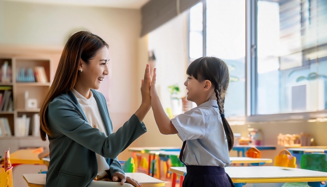 教室でハイタッチをする先生と女の子