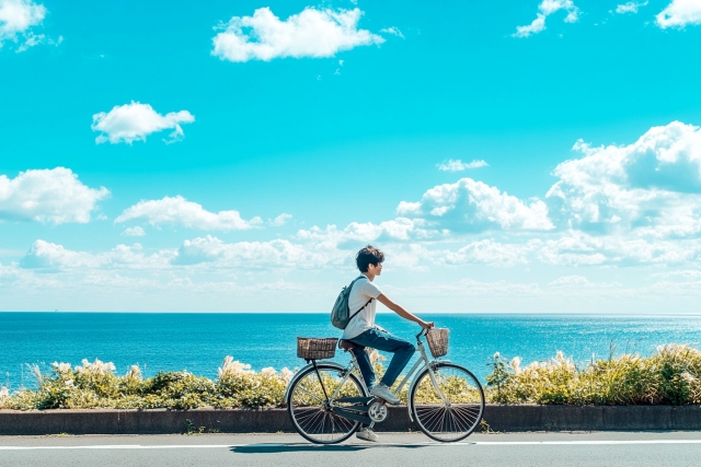 海沿いを自転車で走る男性