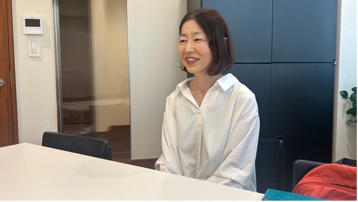 椅子に座り、インタビューに答える介護ヘルパー女性