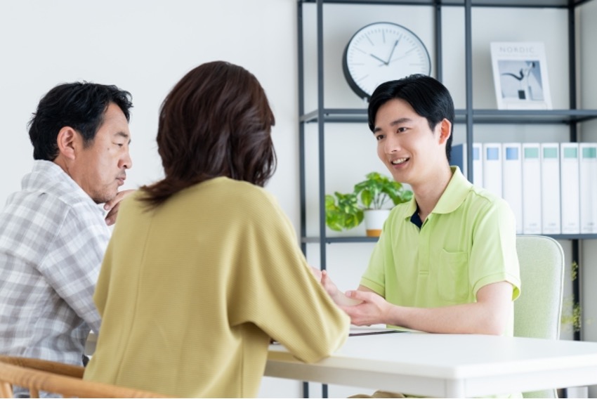 利用家族と話をする男性介護士