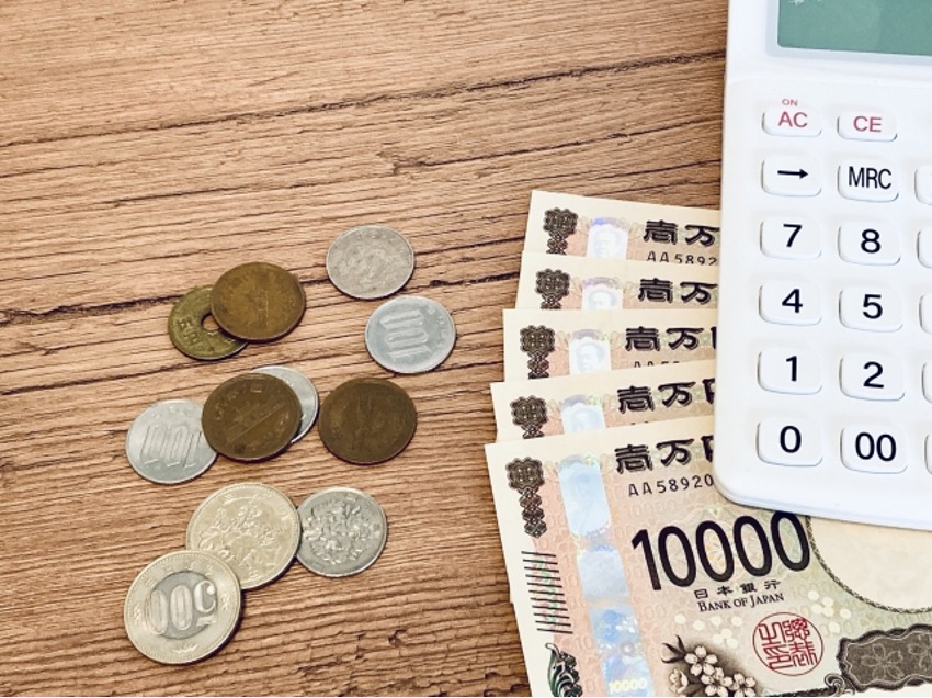 小銭と1万円札5枚、電卓
