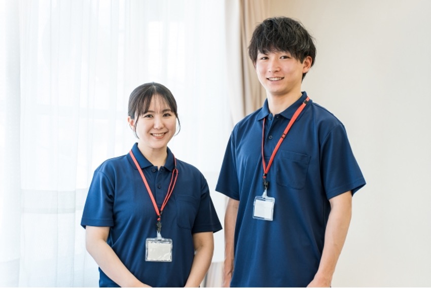 窓付近に立つ青い制服をきた男女