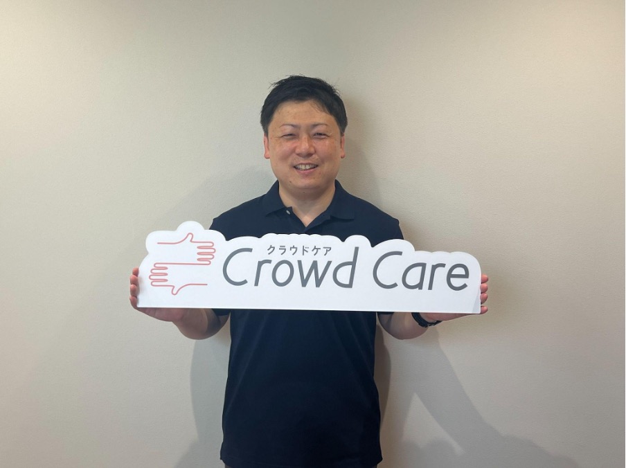 クラウドケアの看板を持つ男性介護保険外へルパー