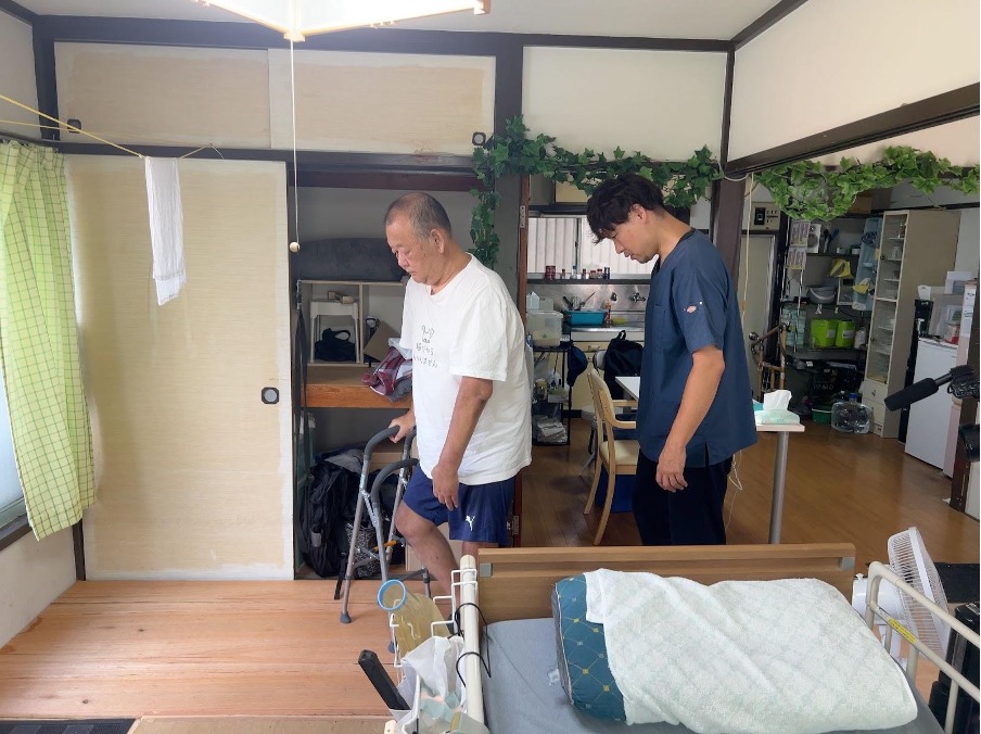 自費訪問リハビリを受ける男性と、リハビリスタッフ