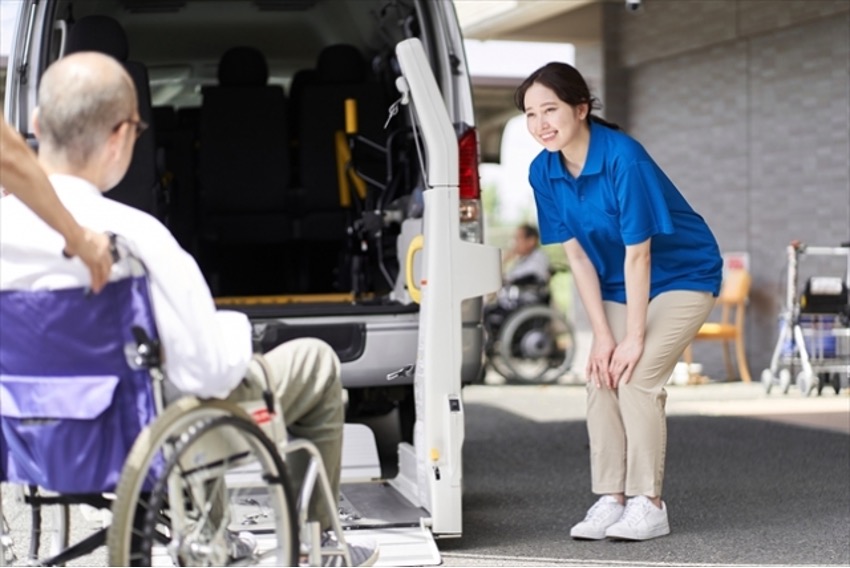 介護タクシーで車椅子の高齢男性を送迎する女性介護士