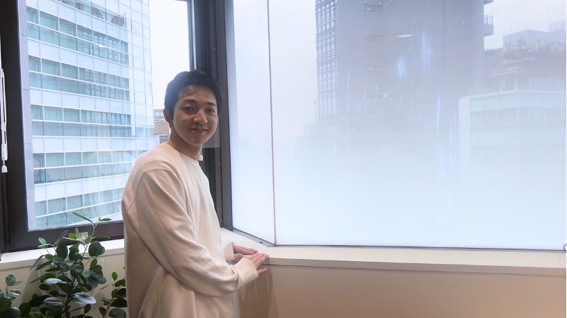 窓際に立つ男性介護ヘルパー
