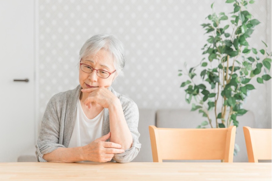 考え込む様子の高齢女性