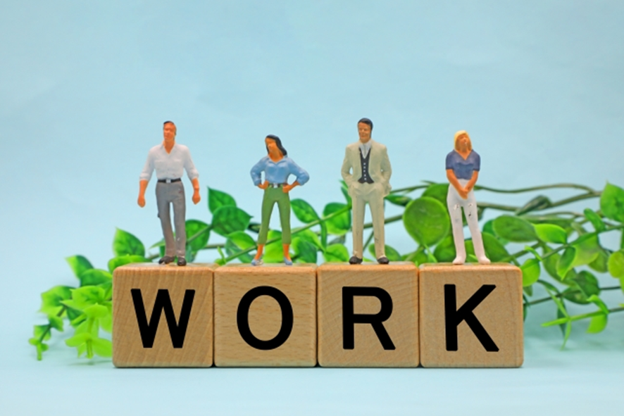 WORKと書かれたブロックと男女4人の人形