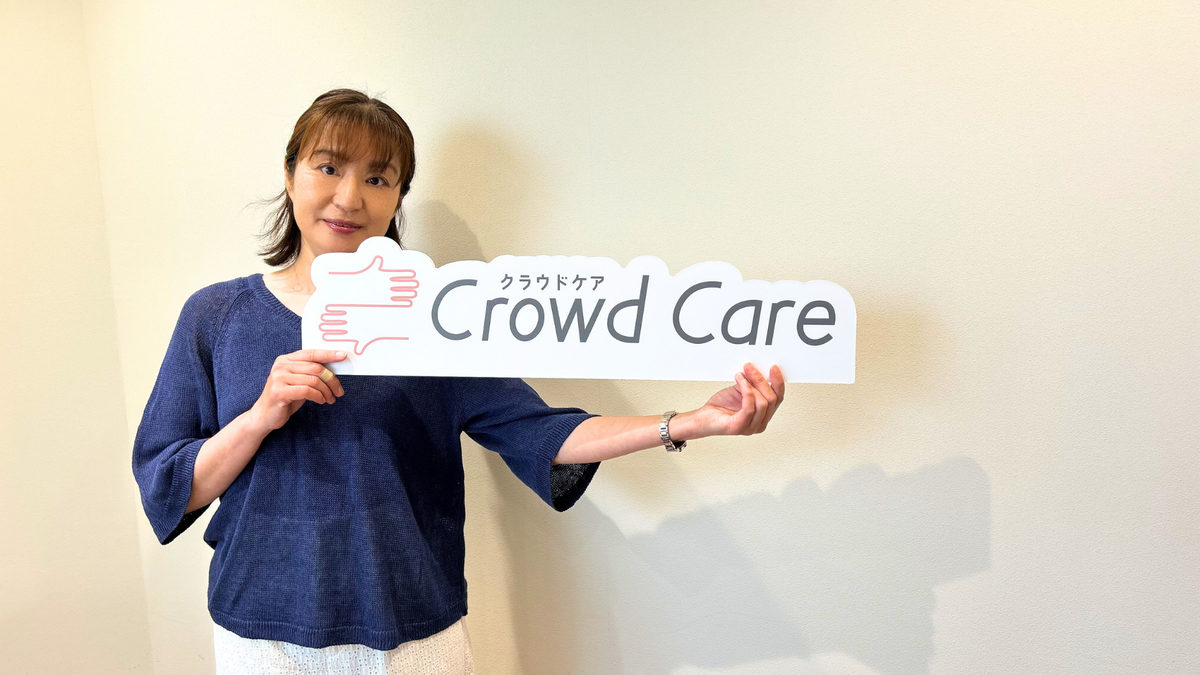 クラウドケアの看板を持つ女性へルパー