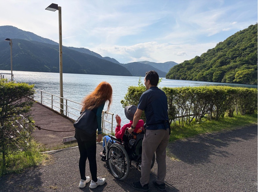 介護旅行を楽しむ車椅子男性と家族、ヘルパー