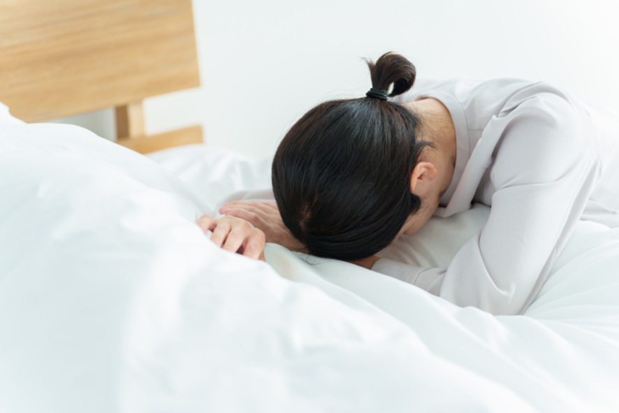 疲れた様子でうつむく女性