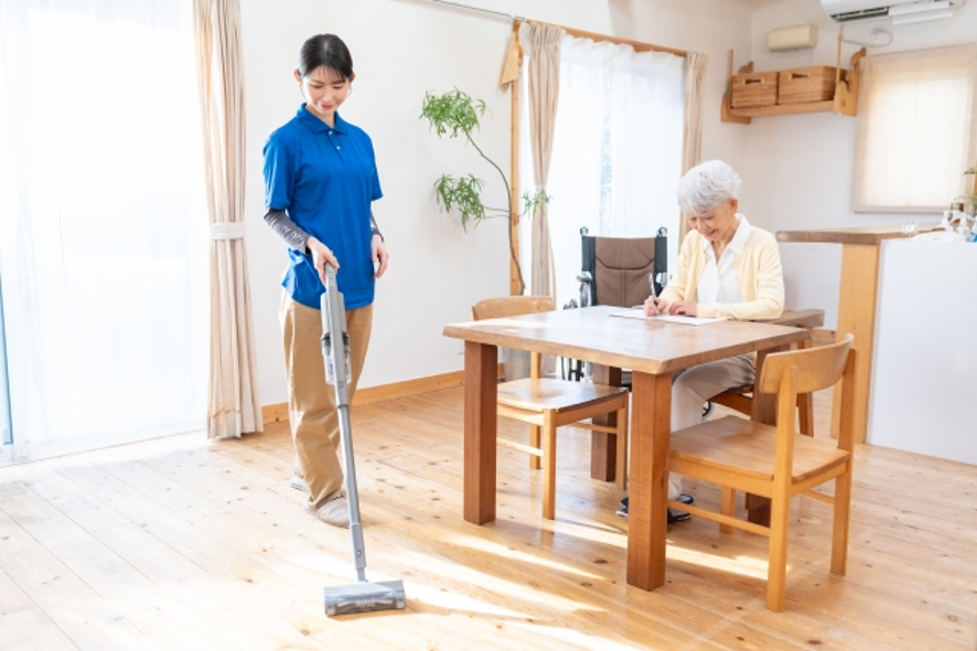 掃除機をかける介護士