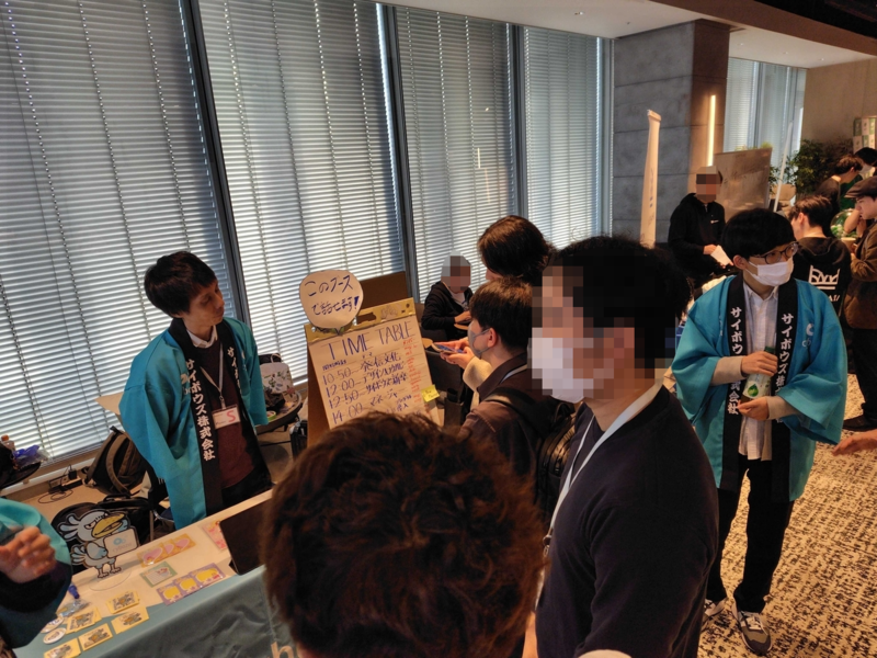 ブースで法被を着て話している2人