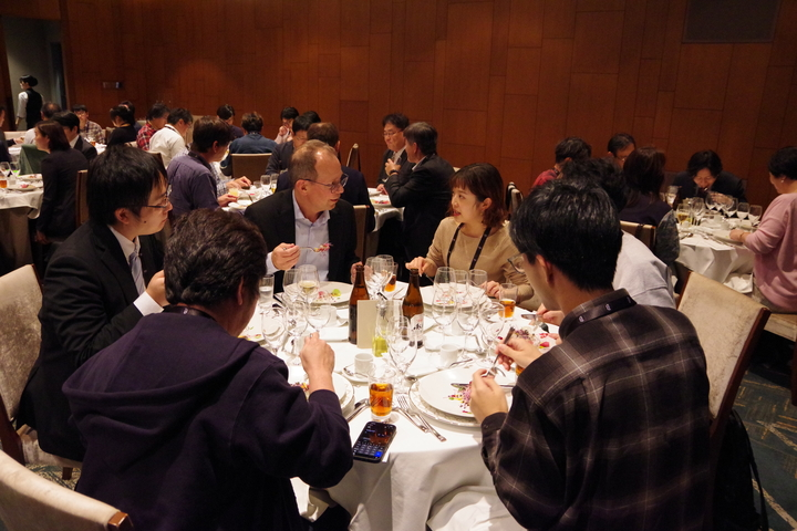 丸い机を囲って数人で食事している。W3C CEO の Seth と弊社 saku さんが話している