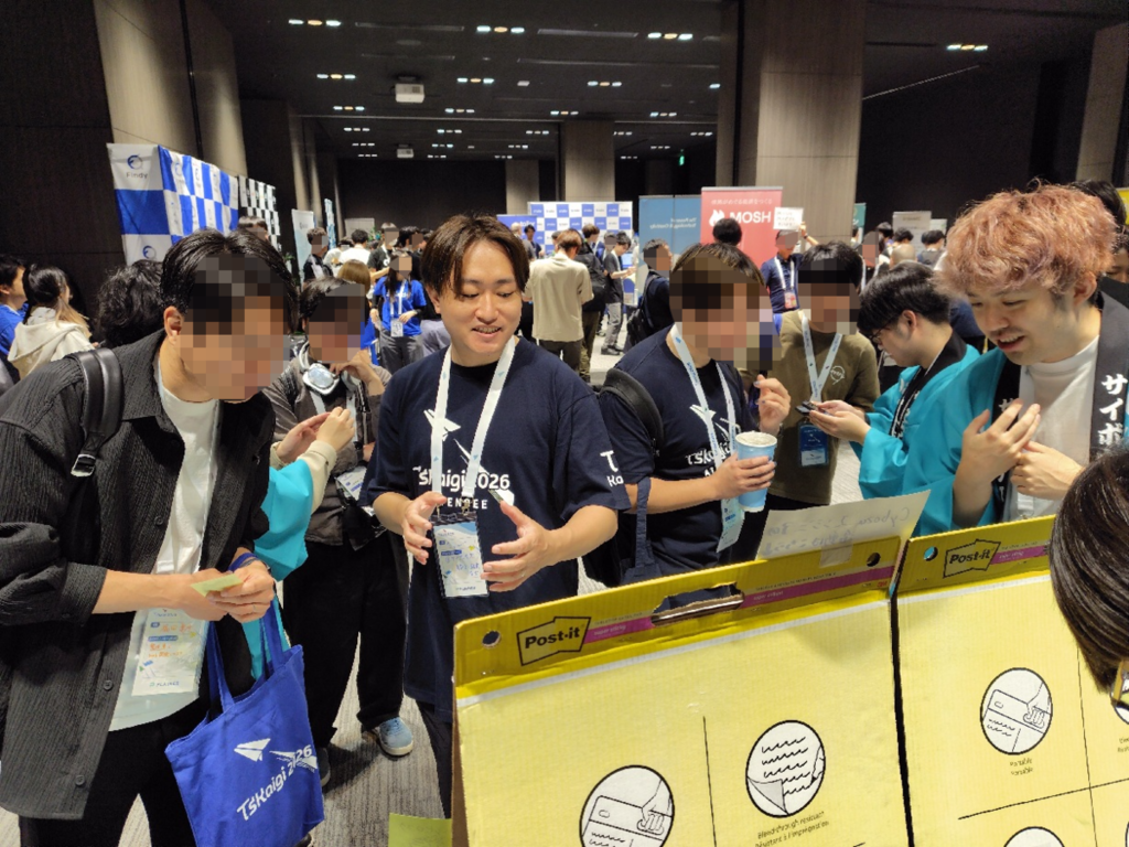 法被を着たサイボウズ社員と話したり、付箋を貼ろうとしたりしている参加者たち。