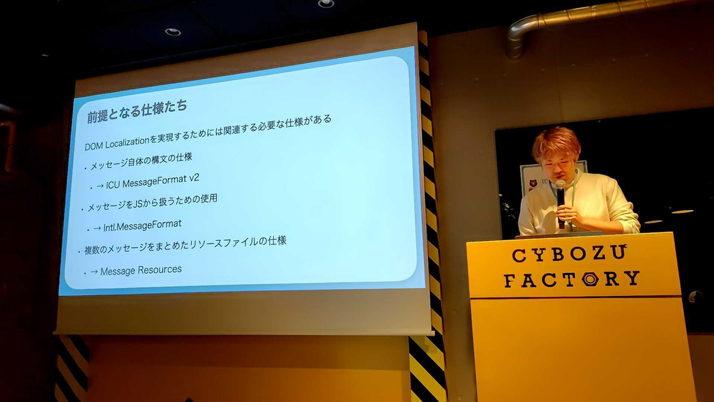 サイボウズ東京オフィスで発表を行っているSajiさん。「前提となる仕様たち」というスライド。