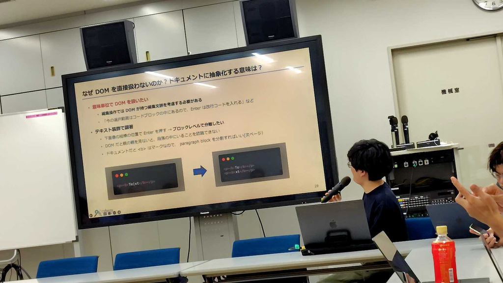 発表を行っているコサキン。「なぜDOMを直接扱わないのか？ドキュメントに抽象化する意味は？」というスライド。