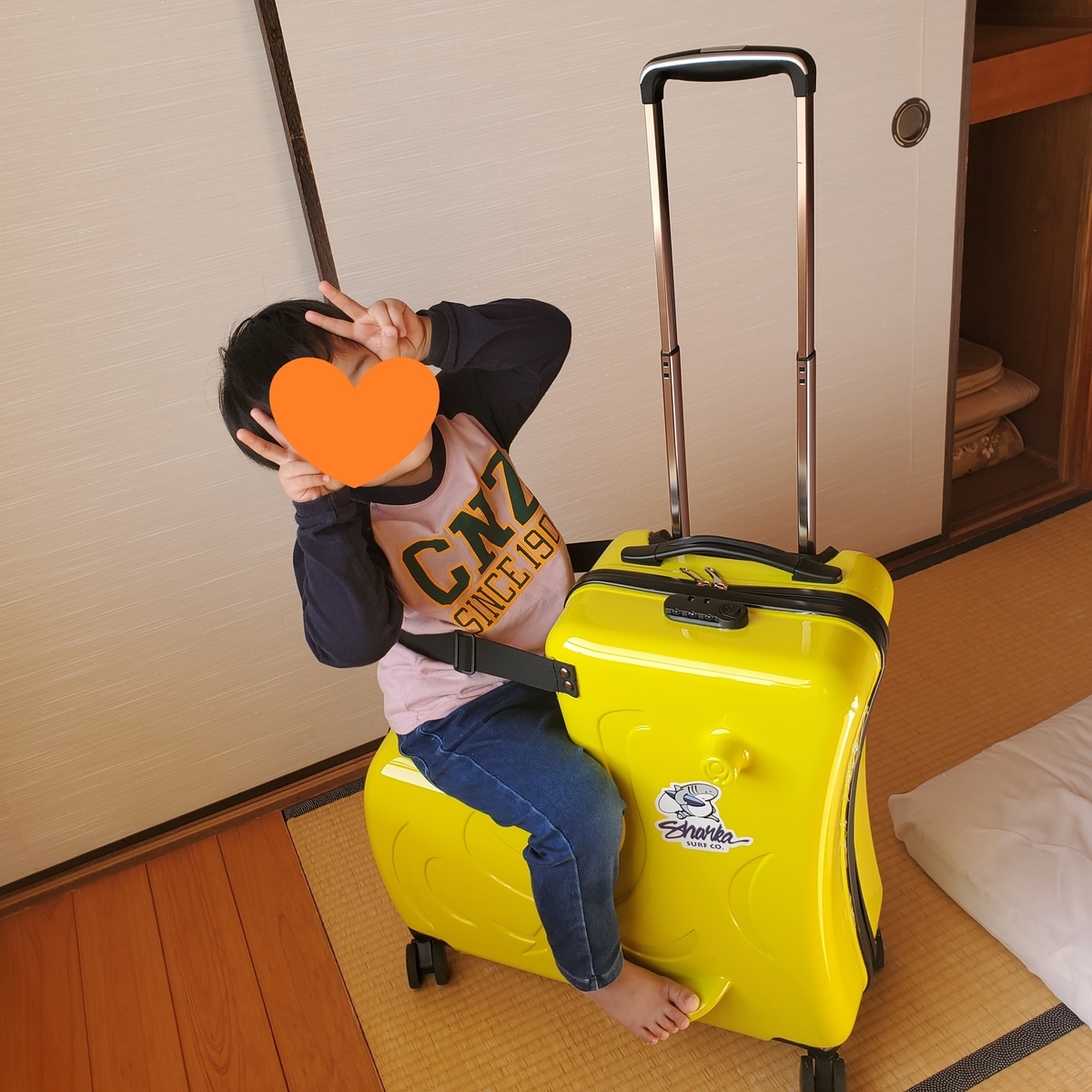 カバンの上に乗って笑顔の息子