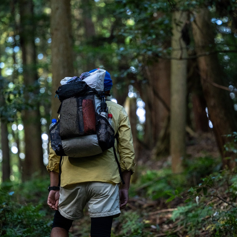 Trail Bum FAB ALUULA 着用イメージ — 山行中、半透明のGraflyteが内容物をうっすら透かす