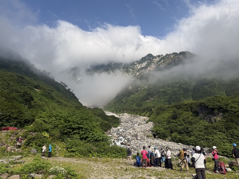 白馬尻で滑り止めを装着する登山者たちと、雲で埋まった谷の奥
