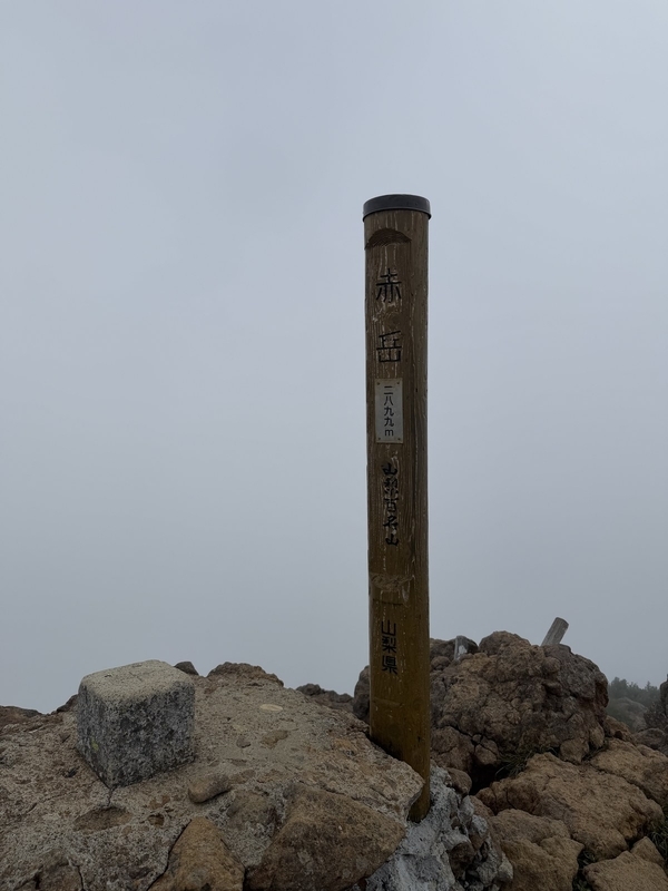 赤岳山頂の標識。周囲は真っ白なガスに包まれている