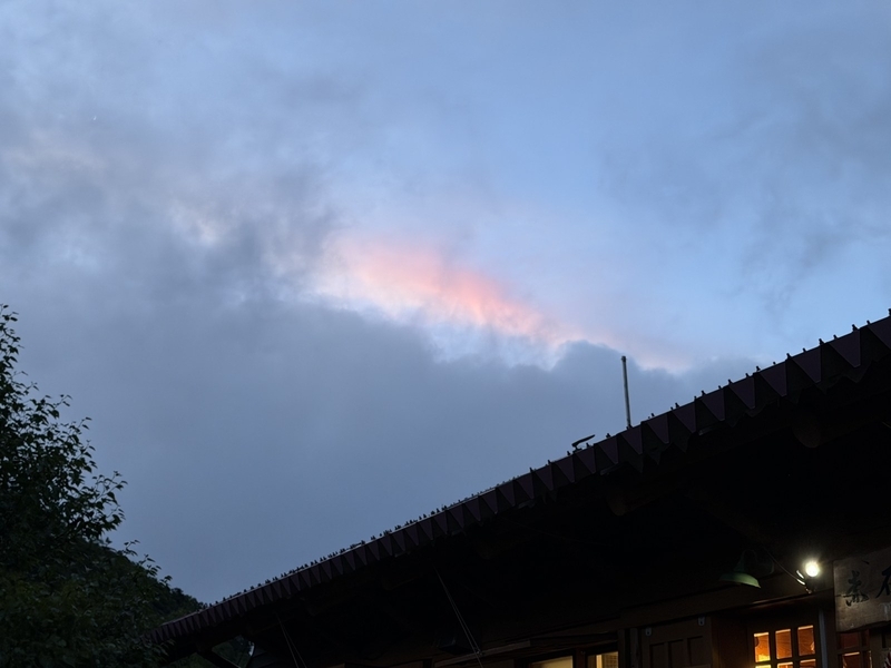 夕方の赤石小屋の屋根の上に出た、雲の縁が虹色に染まる彩雲