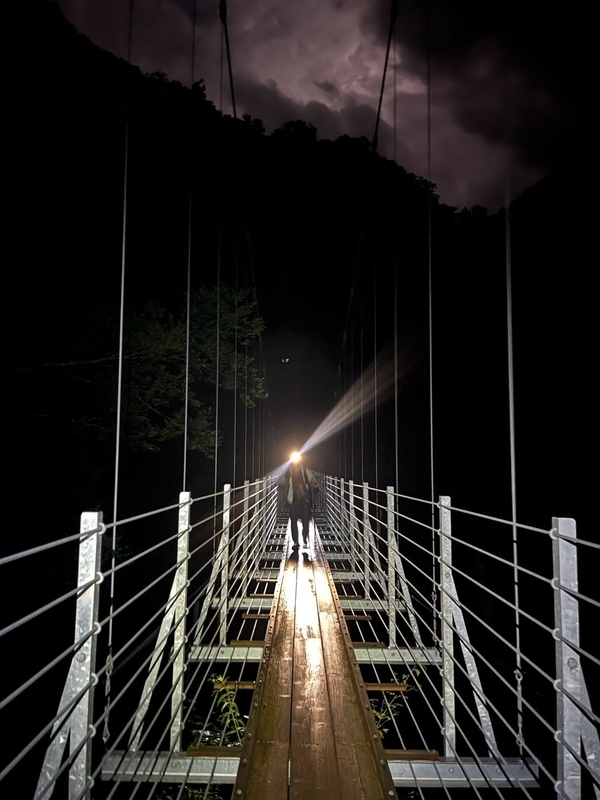 夜の滝見橋。ヘッドランプの光に浮かぶ吊り橋のワイヤーと踏み板
