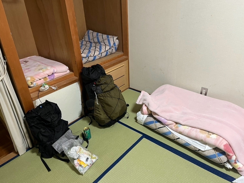 椹島ロッヂの和室。布団が敷かれ、ザックが2つ置かれている
