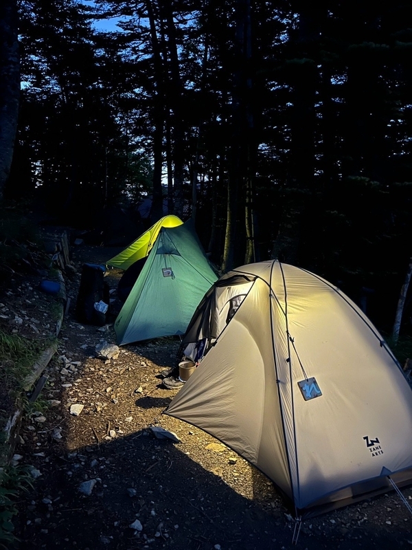 夜の赤石小屋テント場。ランタンの灯りに浮かぶテント