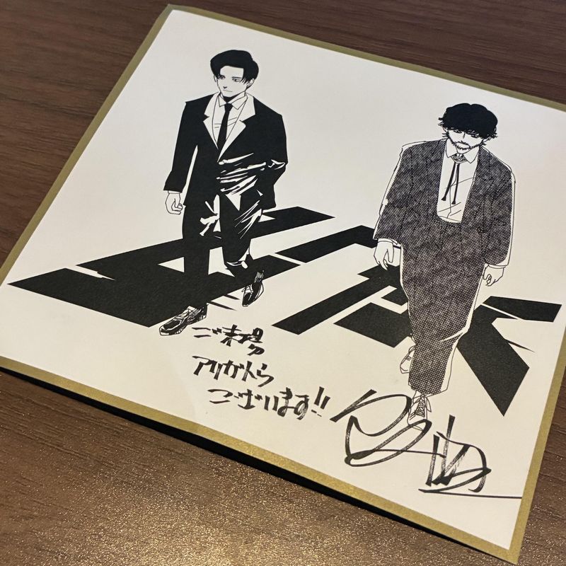 『ひゃくえむ。』入場者プレゼント第一弾。成長したトガシと小宮が肩を並べて立っている