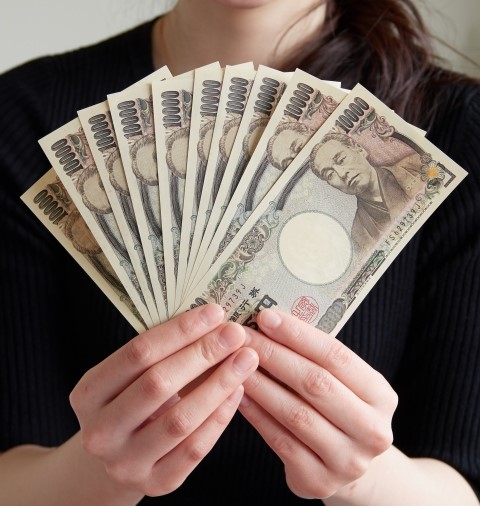 １０万（１万円札１０枚）を胸元で扇子のように広げる女性