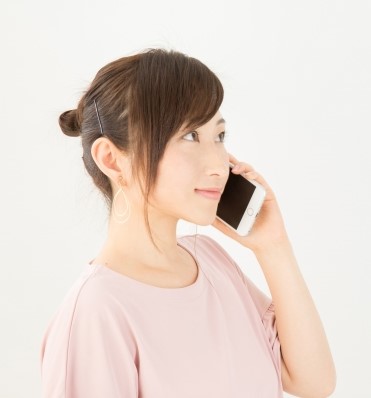 スマホで前に働いていた店に電話をかける女性