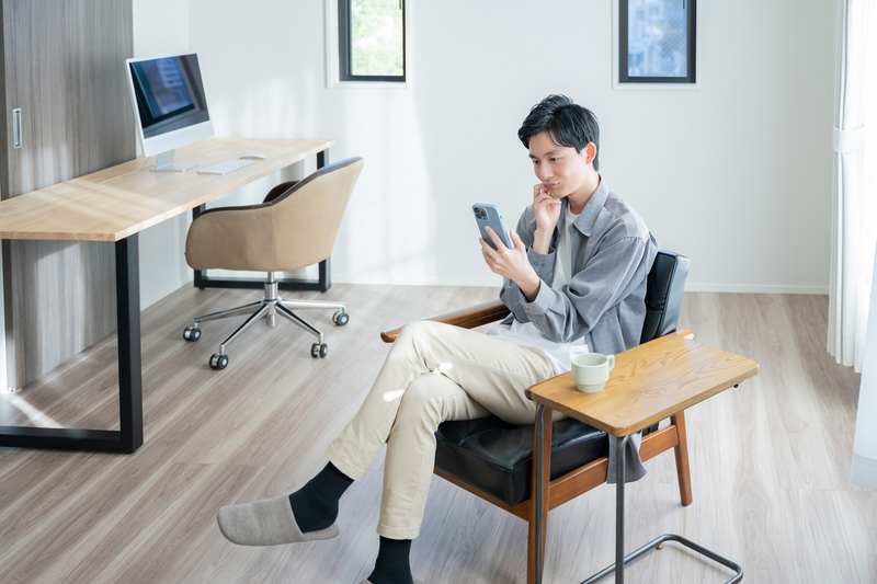 目の前の仕事からの逃げ癖がついてスマホを見る男性