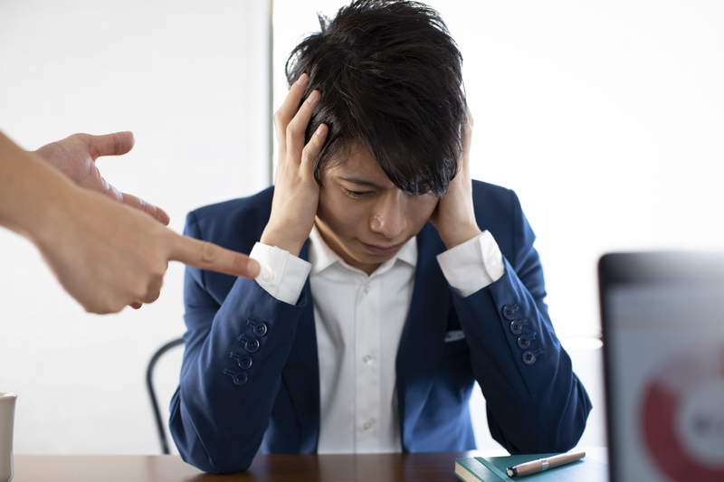 上司に怒られて頭を抱えるイメージ