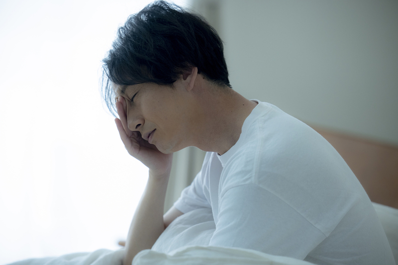 嫌な夢を見て目覚めた人のイメージ