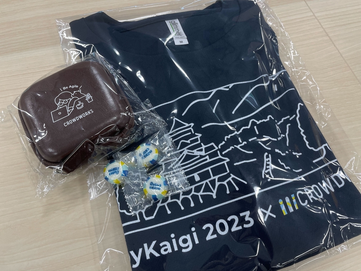 RubyKaigiのロゴをあしらったTシャツとレザースタイルマルチケース、クラウドワークスのロゴ組飴