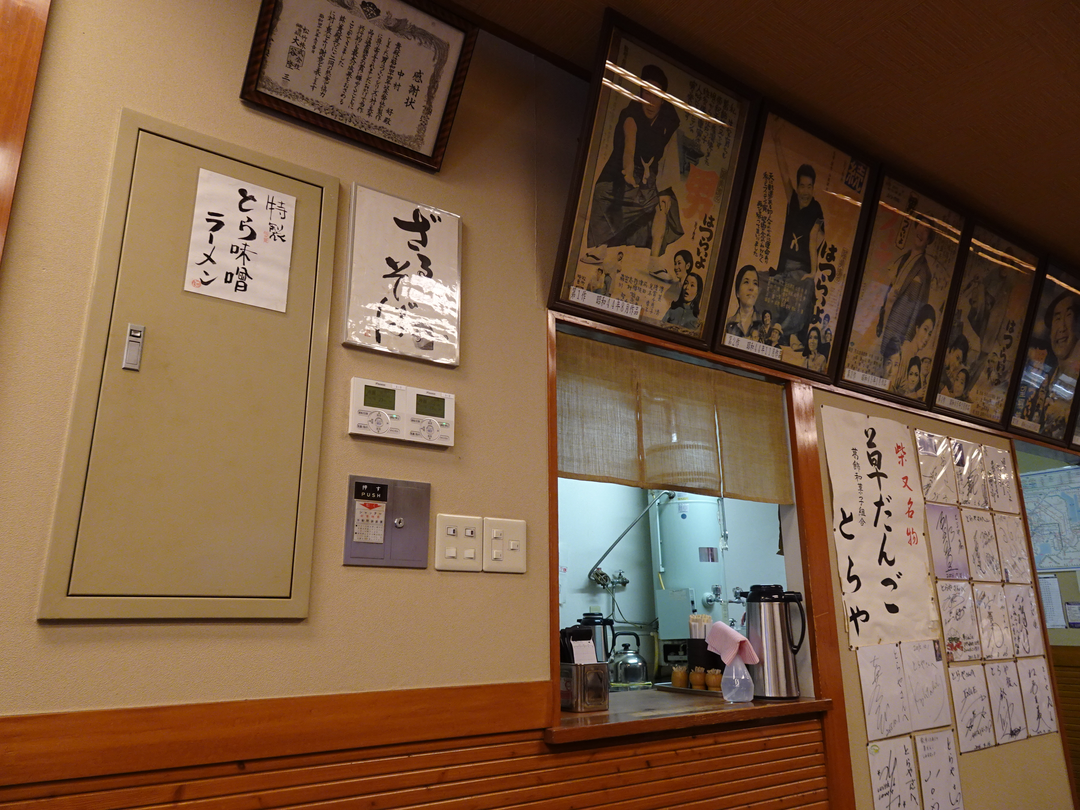 映画『男はつらいよ』シリーズのポスターと来店した著名人のサイン、松竹株式会社からの感謝状が掲げられた店内