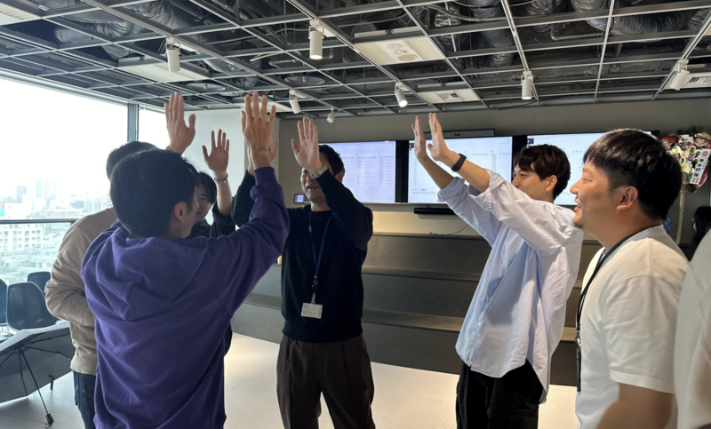 初約定を喜び、皆でHigh Fiveする様子