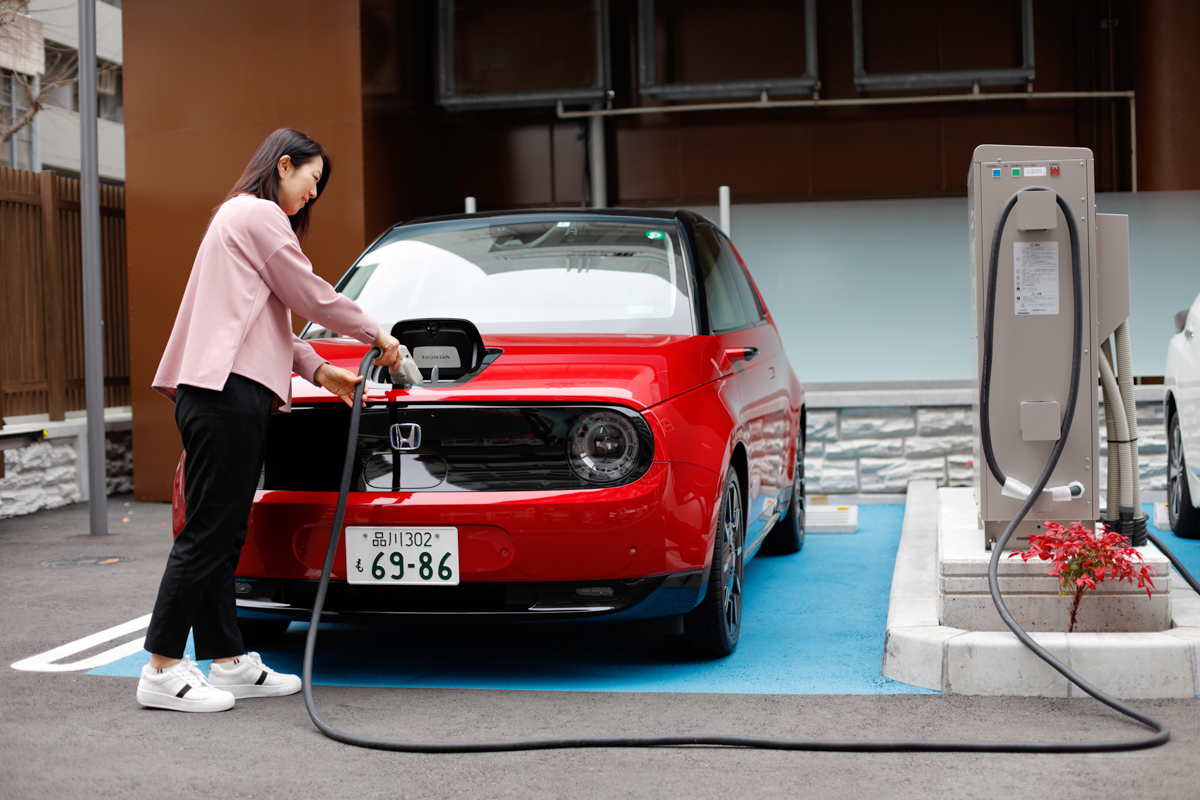 電気自動車（EV）に充電する女性